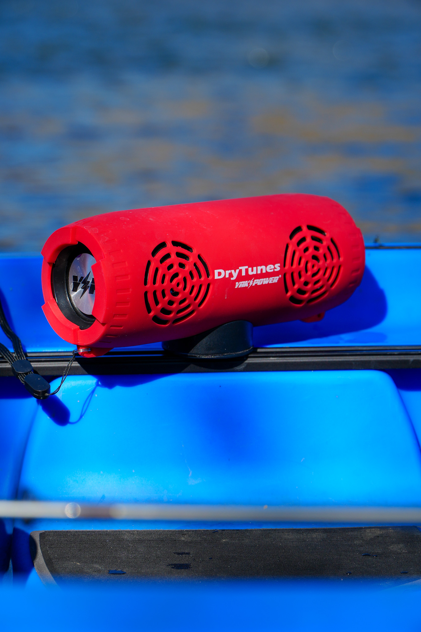 Red DryTunes speaker mounted to the rail of a blue kayak